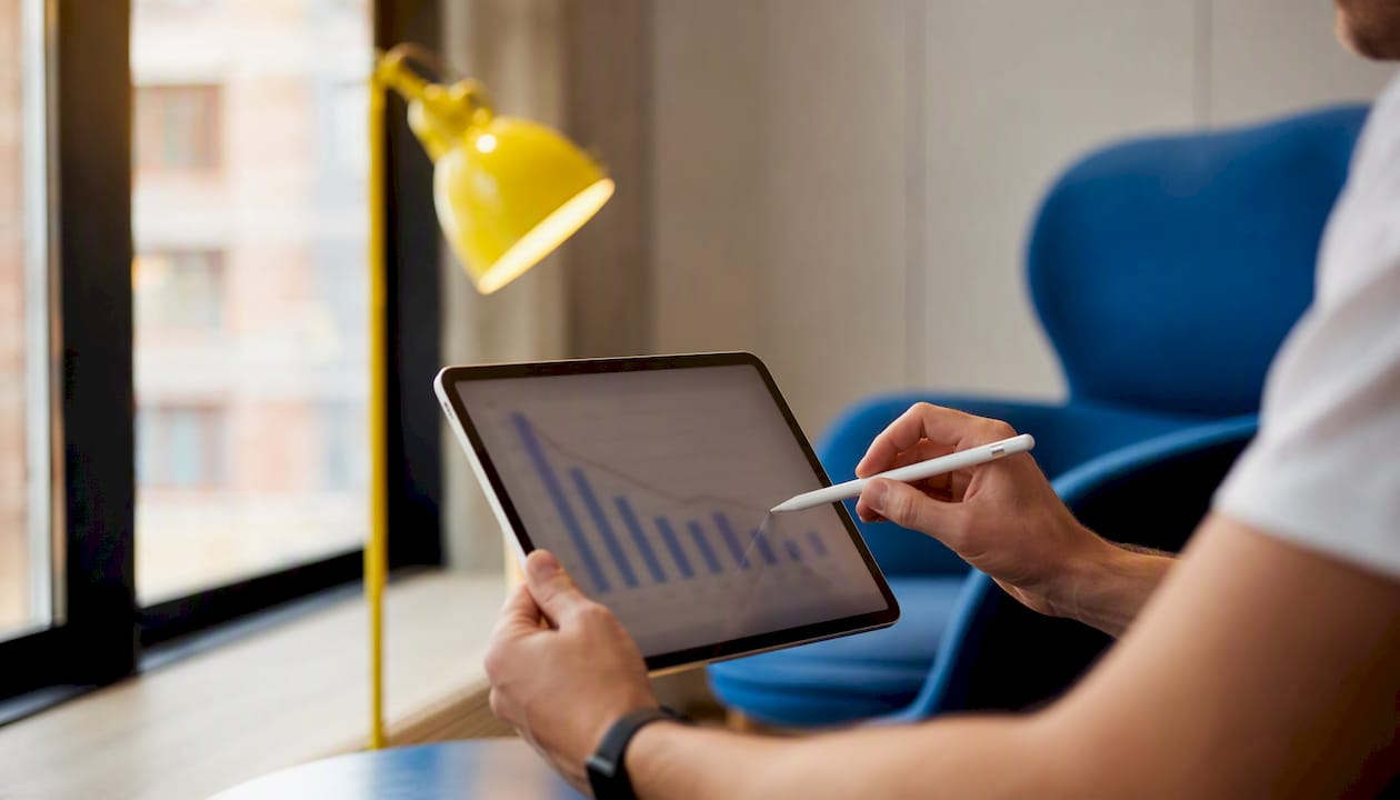Hands pointing at conversion data on tablet