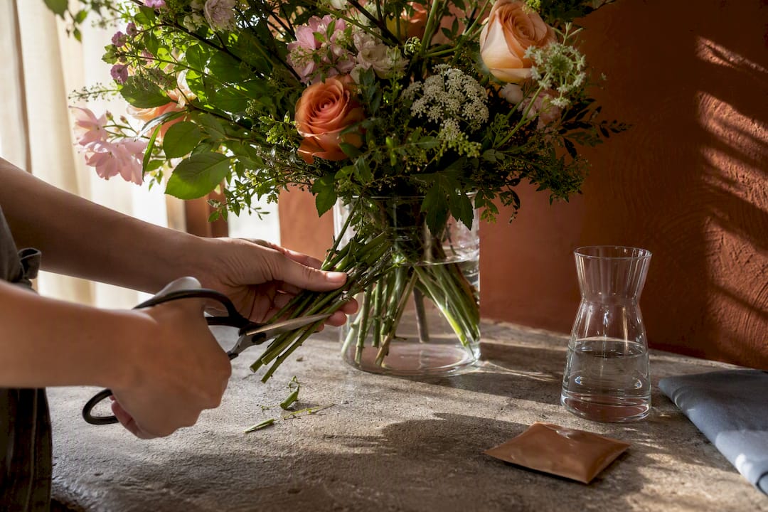 Hands trimming bouquet stems for care