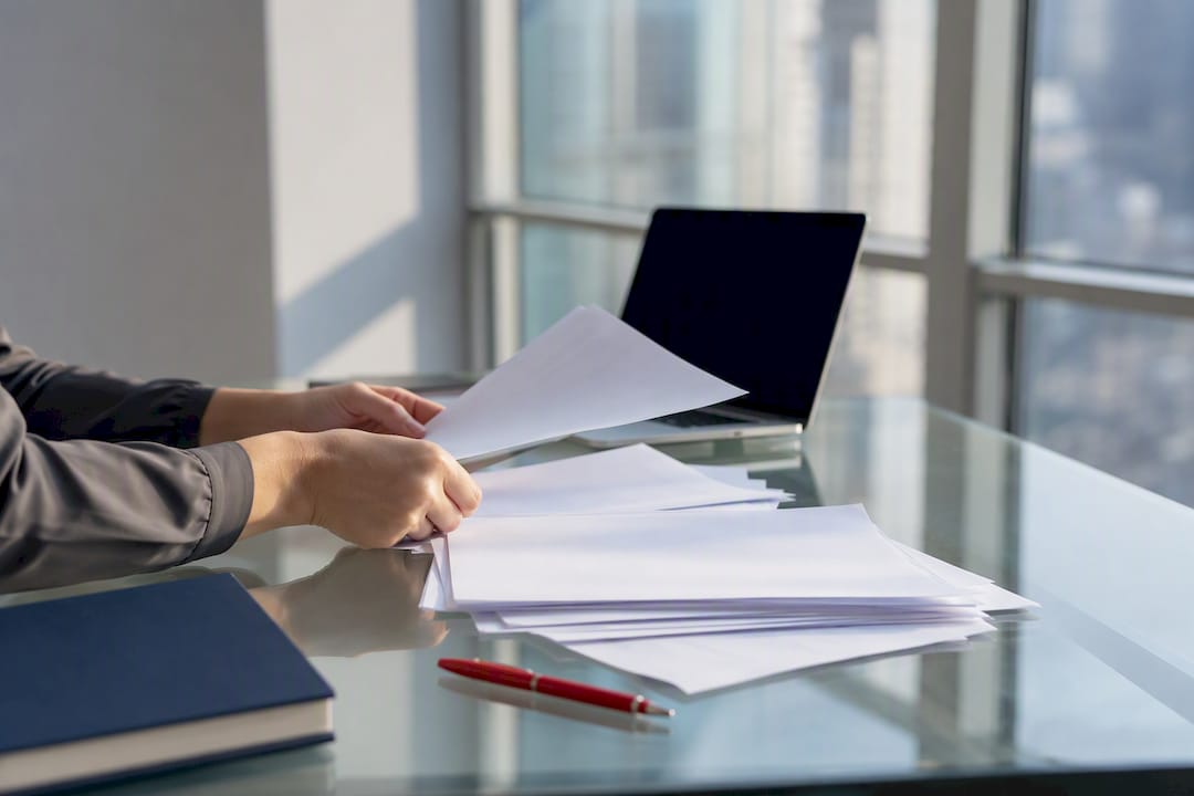 Hands organizing immigration documents on desk