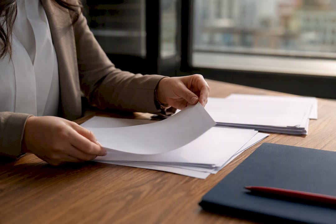 Hands organizing immigration documents in office