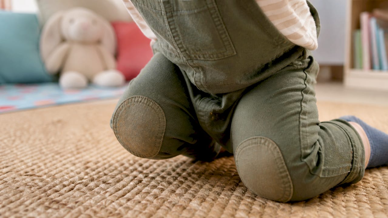 Reinforced knees on baby dungarees in crawling position