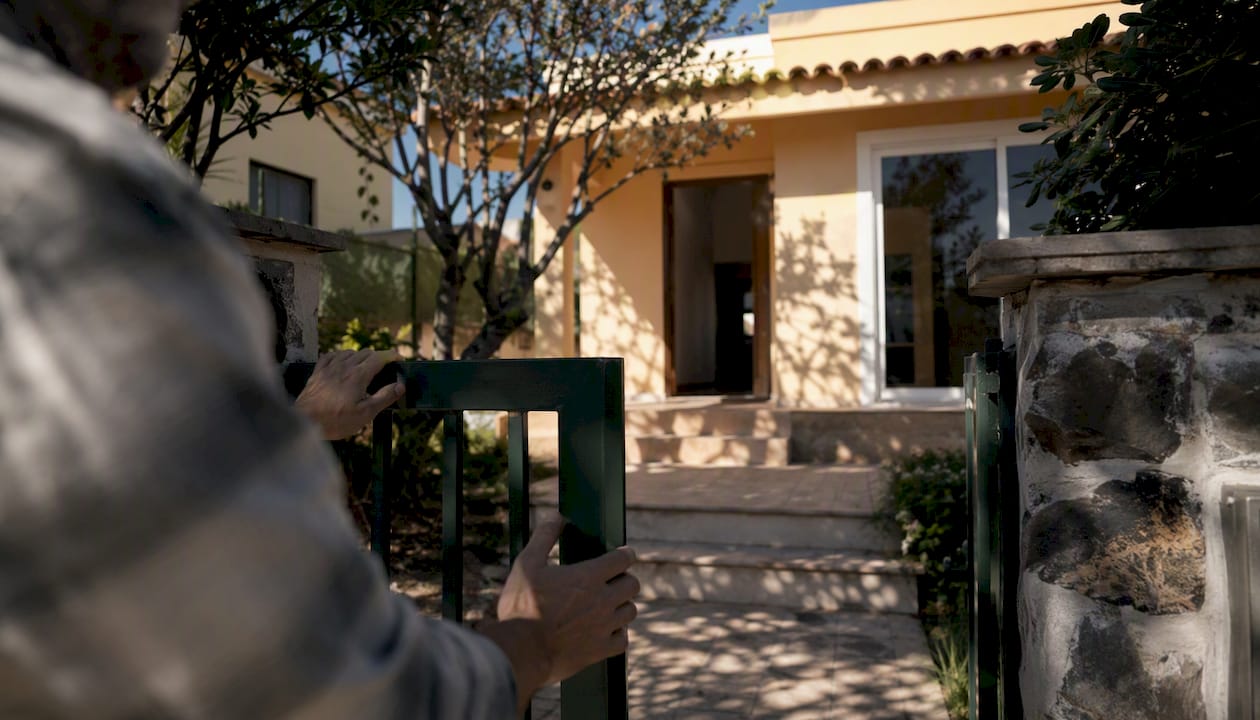Propietario revisando el estado exterior de una vivienda desocupada