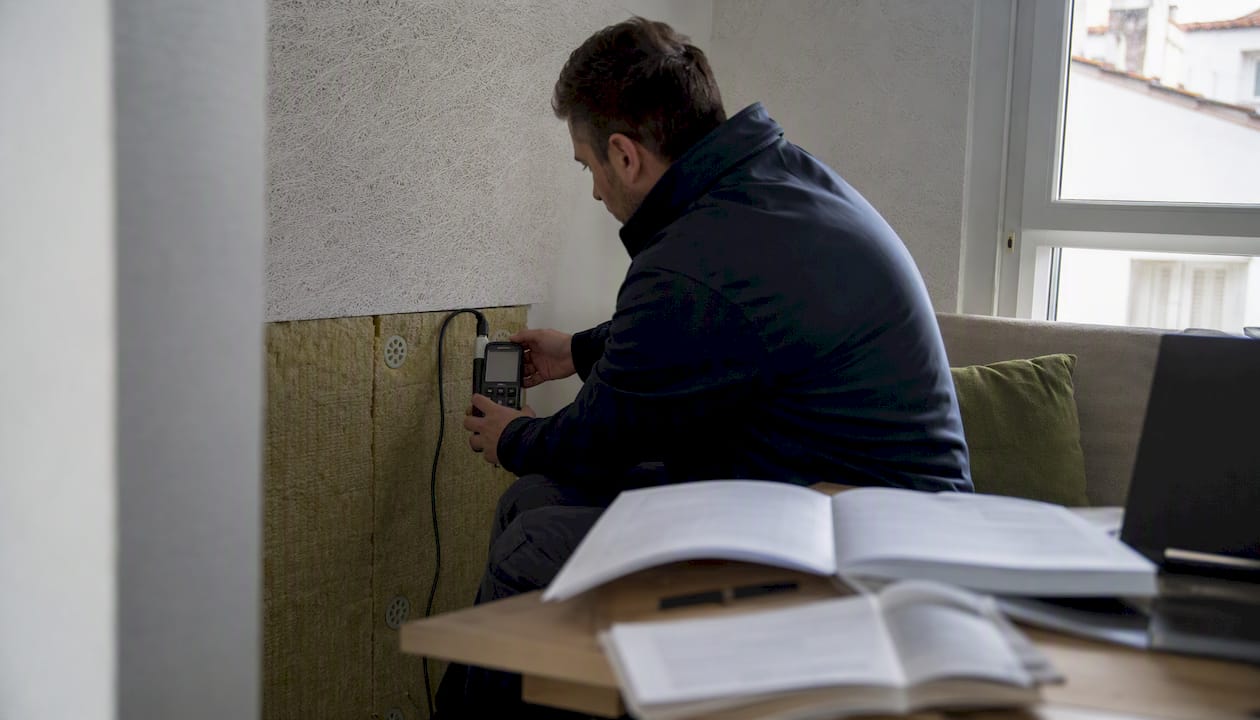 Unas manos regulan el medidor de energía instalado en la pared.