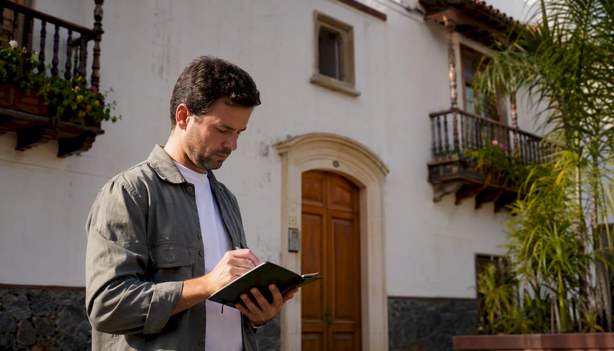 Profesional inmobiliario valorando la fachada de una casa en Tenerife