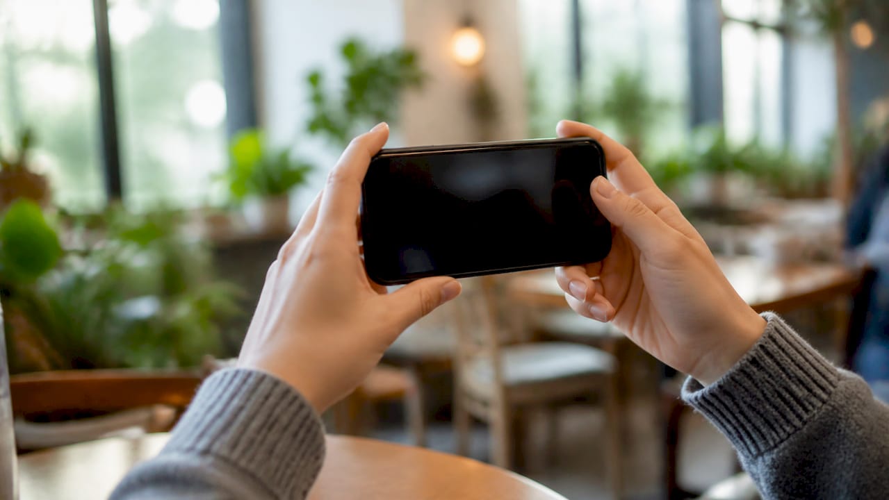 Hands holding phone recording testimonial video