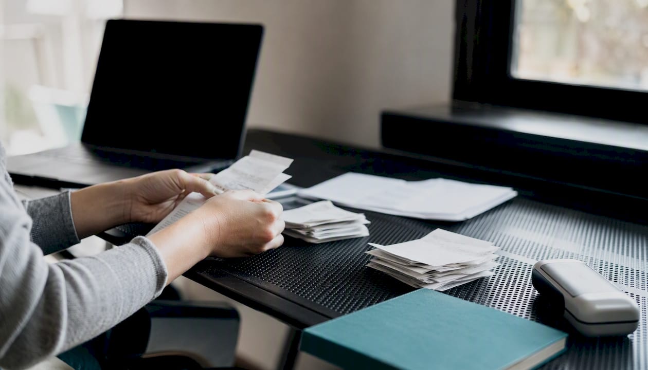 Hands sorting receipts on desk