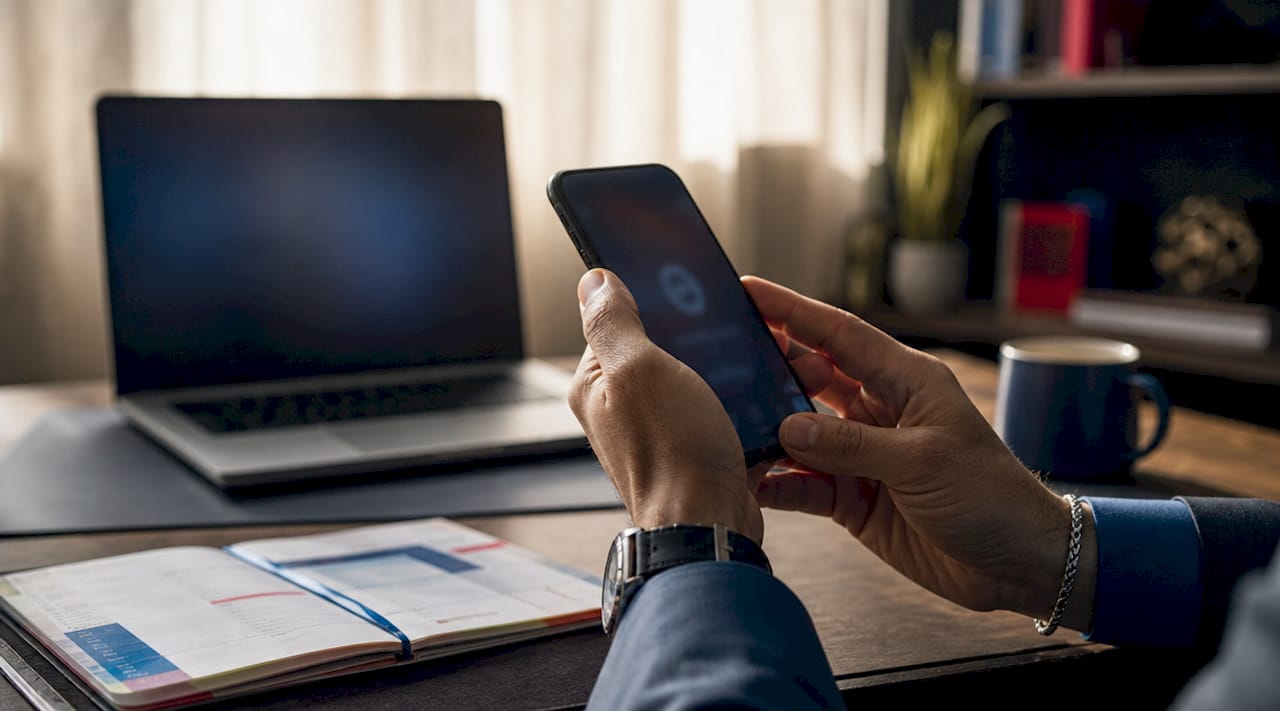 Due mani tengono uno smartphone su cui compare un codice di autenticazione
