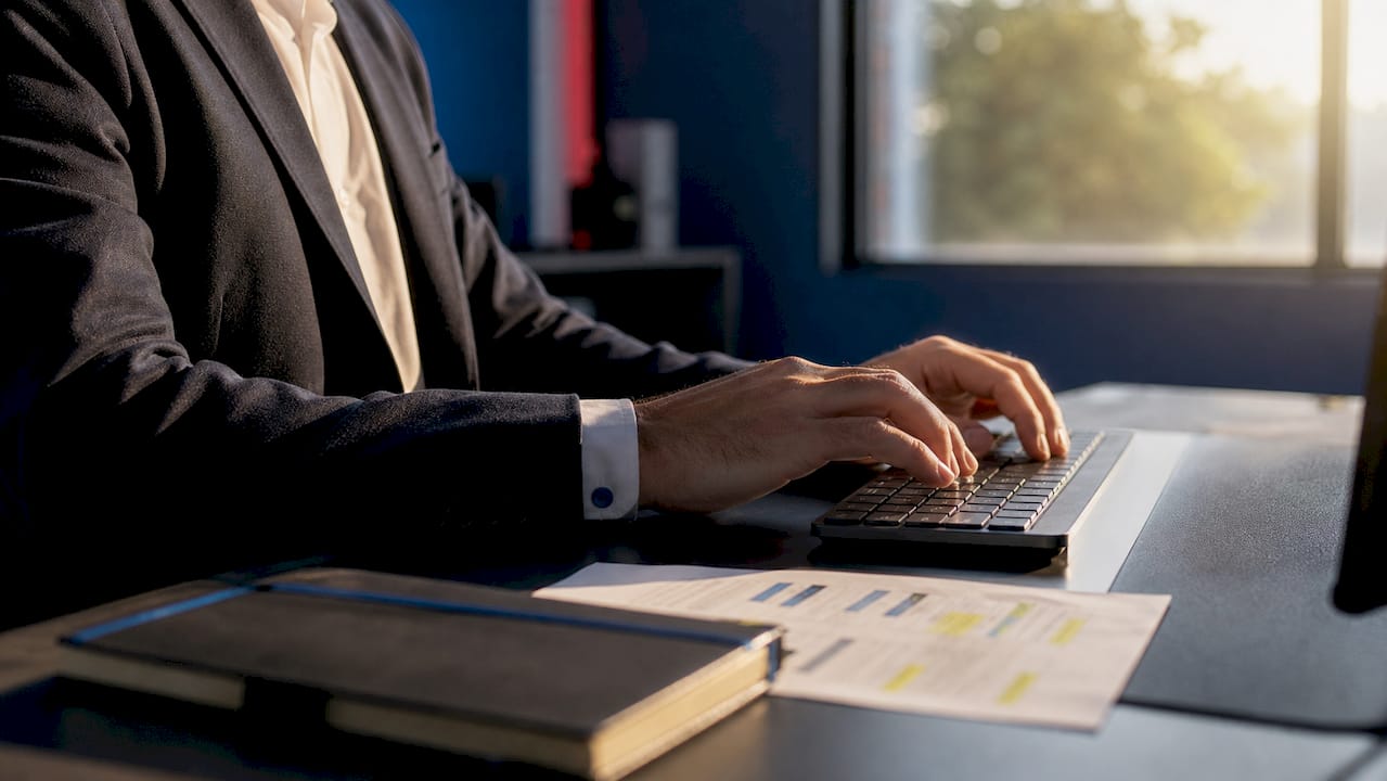 Mani che digitano sulla tastiera accanto a una lista di cose da fare e a un calendario
