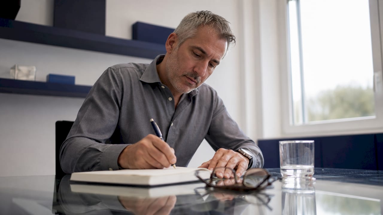 Un uomo sta compilando il registro dei dati personali, annotando con cura ogni dettaglio del trattamento.