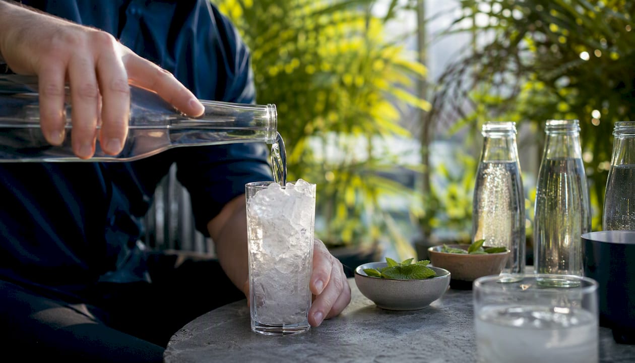 Pouring vodka with low-calorie mixers on kitchen counter