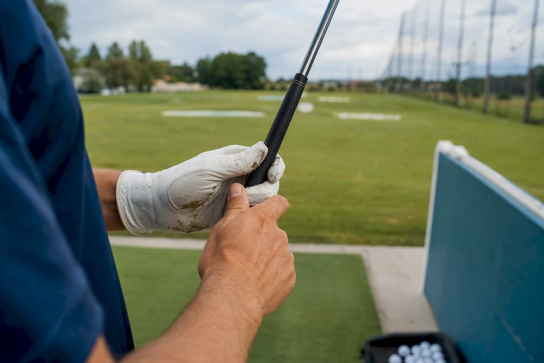 Golfer adjusting grip on golf club