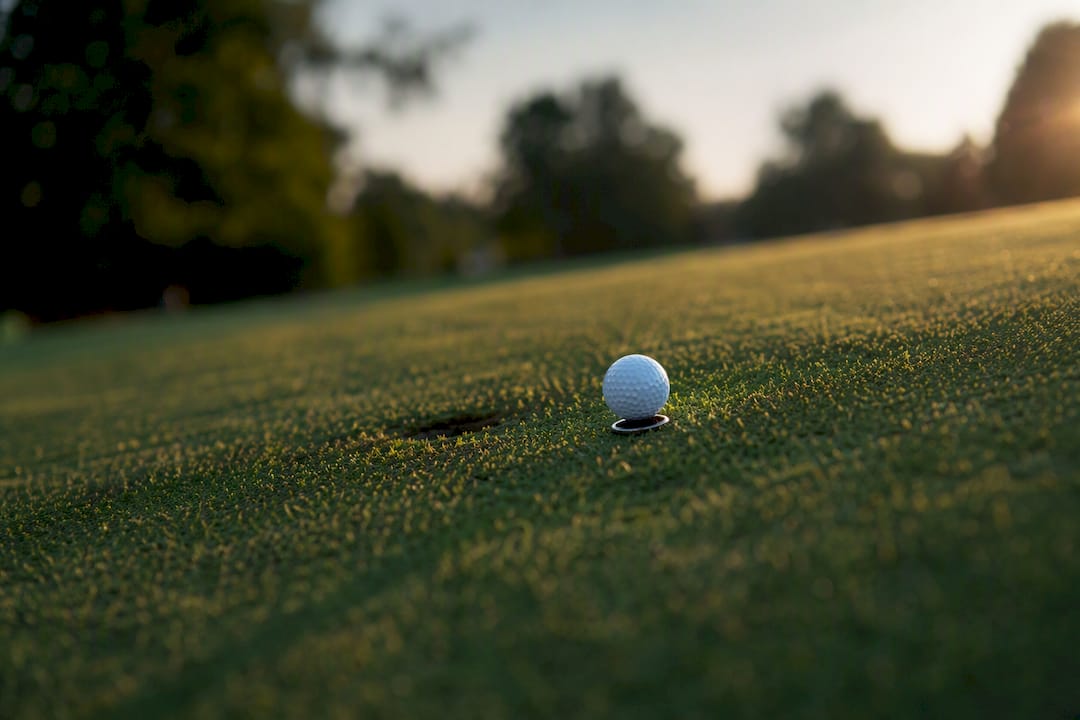 Golf ball marker on slope affected by wind