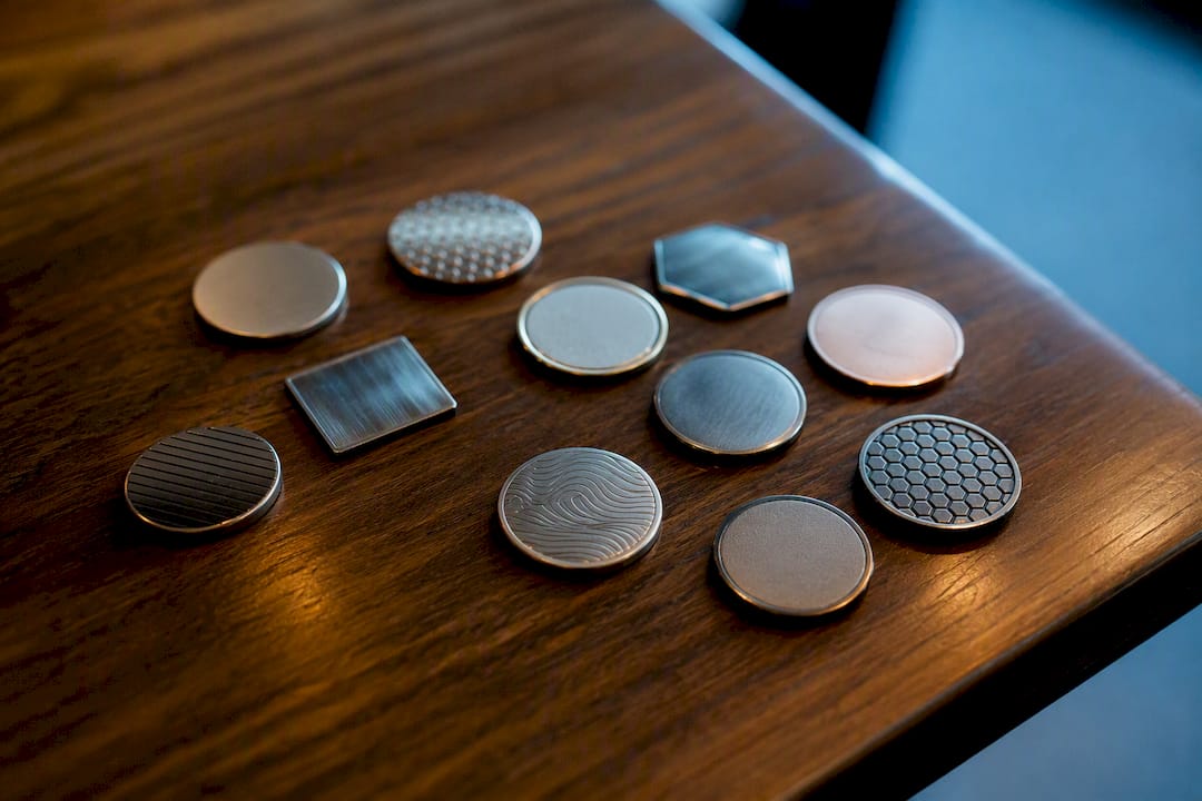 Assorted golf ball markers on navy surface