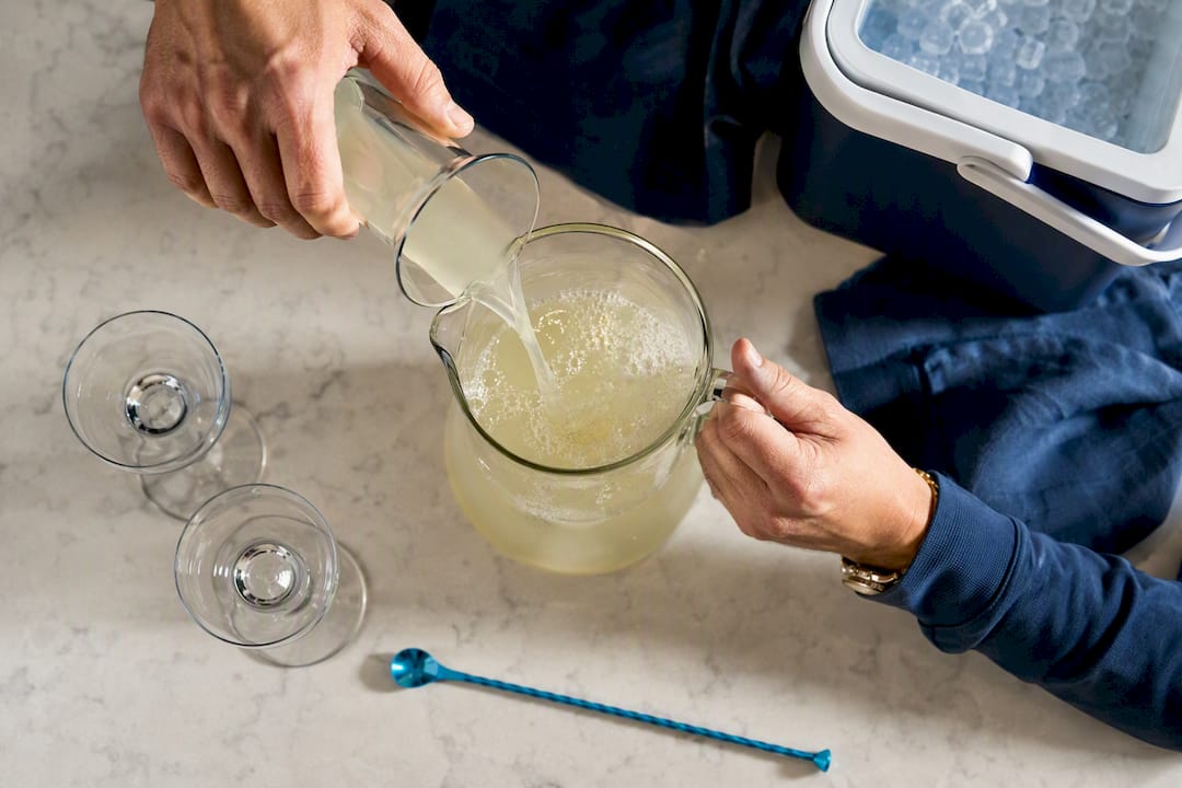 Hands batching an Azalea cocktail pitcher