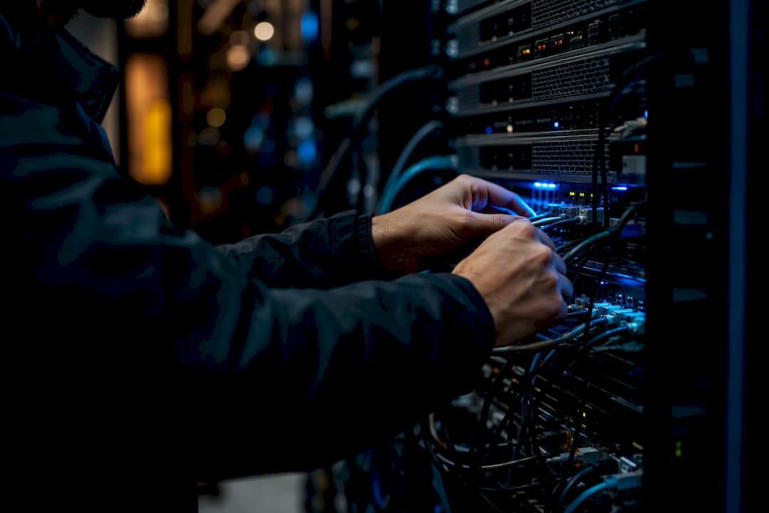 Hands connecting encrypted data cables in server room