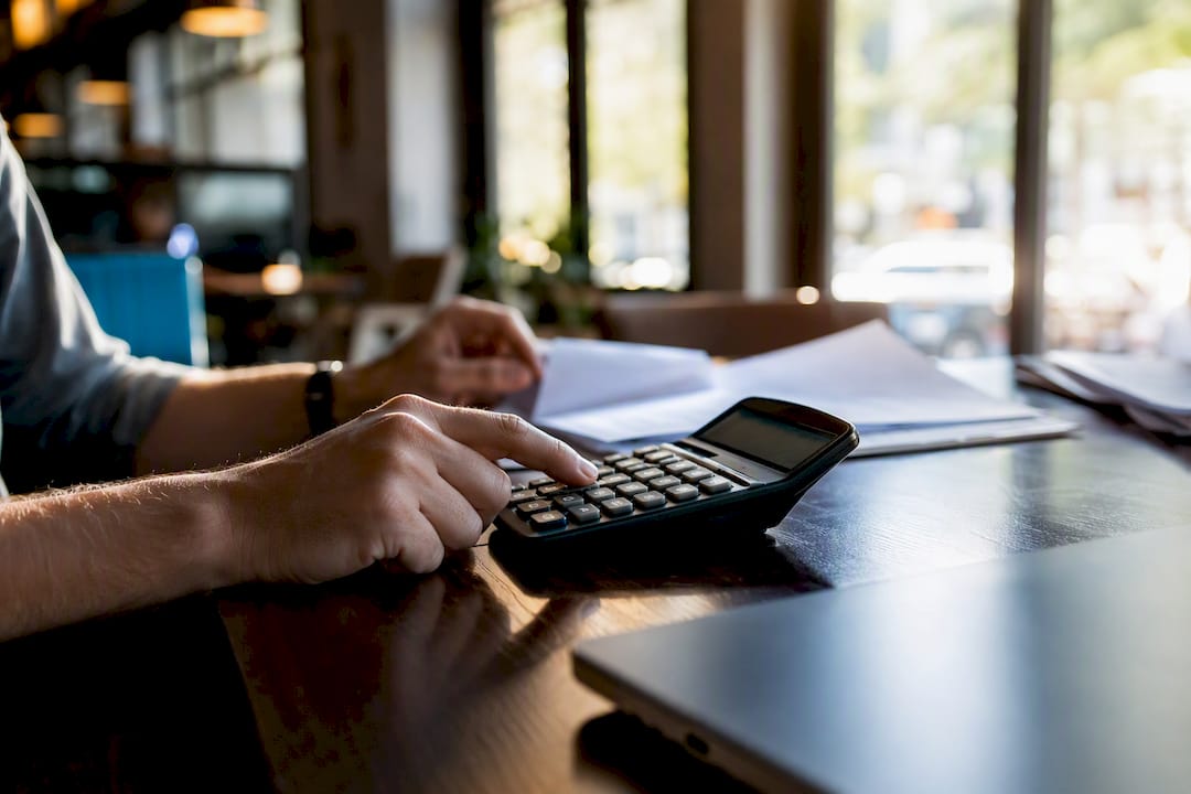 Hands calculating project fee with calculator
