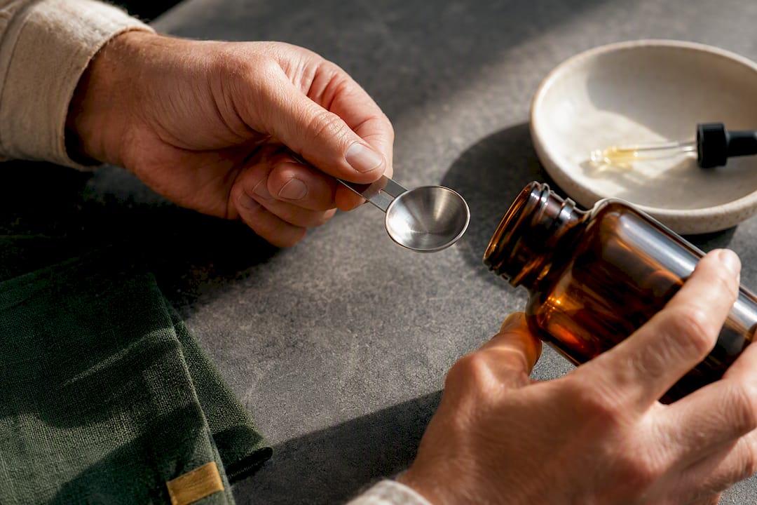 Hands measuring a vitamin supplement dose