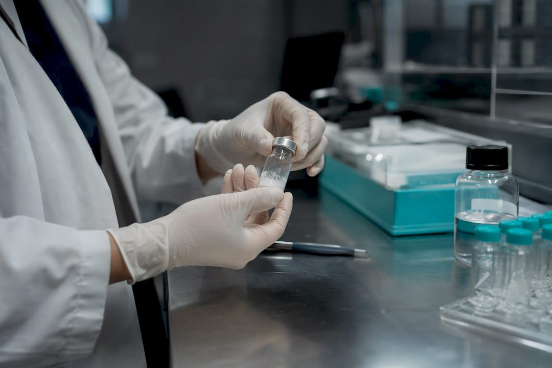 Hands mixing peptide vaccine formulation in lab