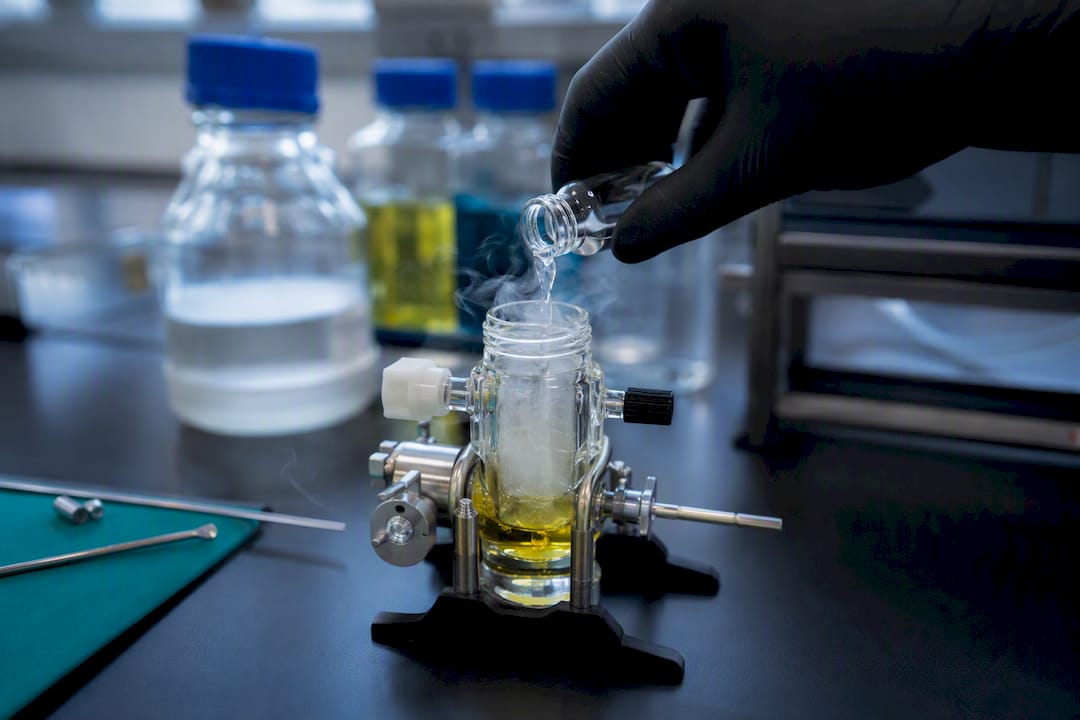 Gloved hand adding piperidine to vial
