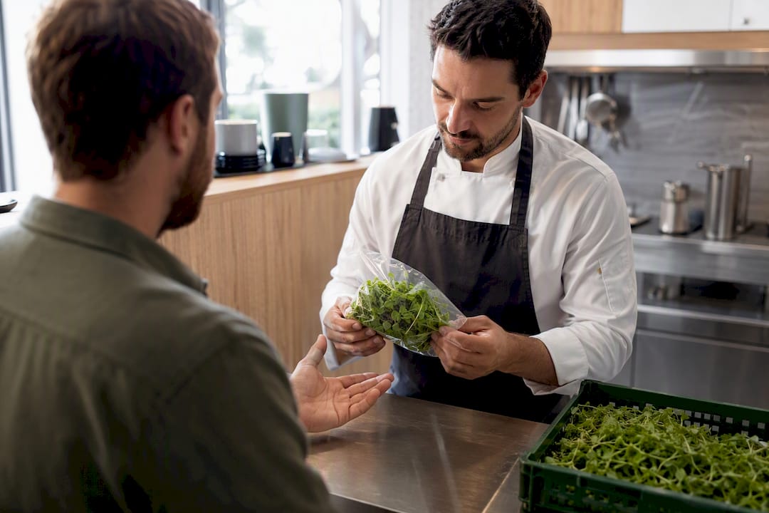 Grower presenting microgreens sample to chef