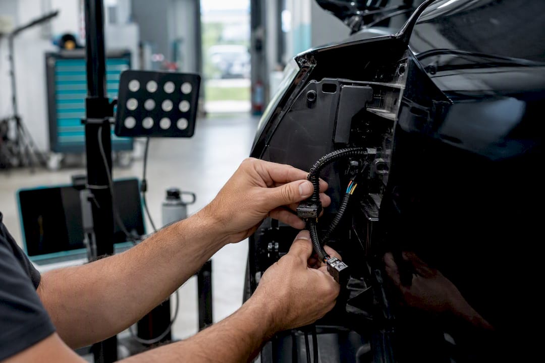 Hands inspecting ADAS sensor wiring