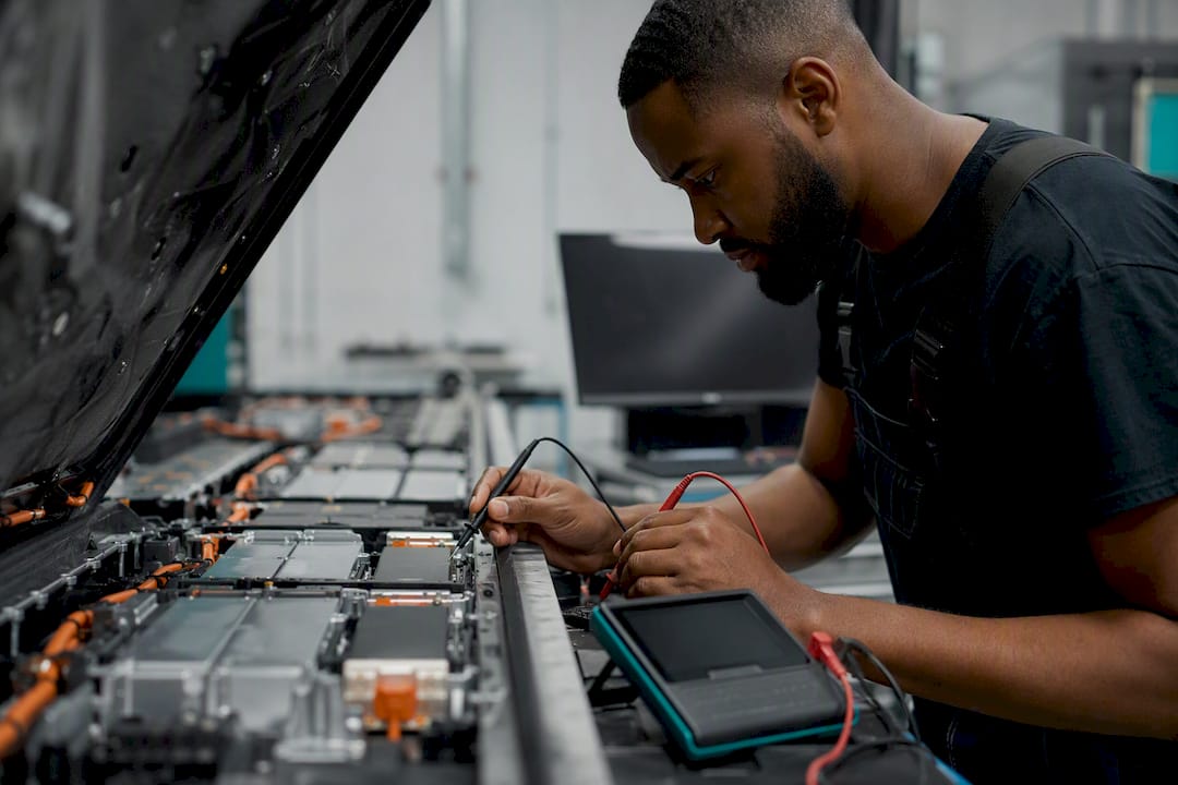 Hands inspecting electric vehicle battery pack