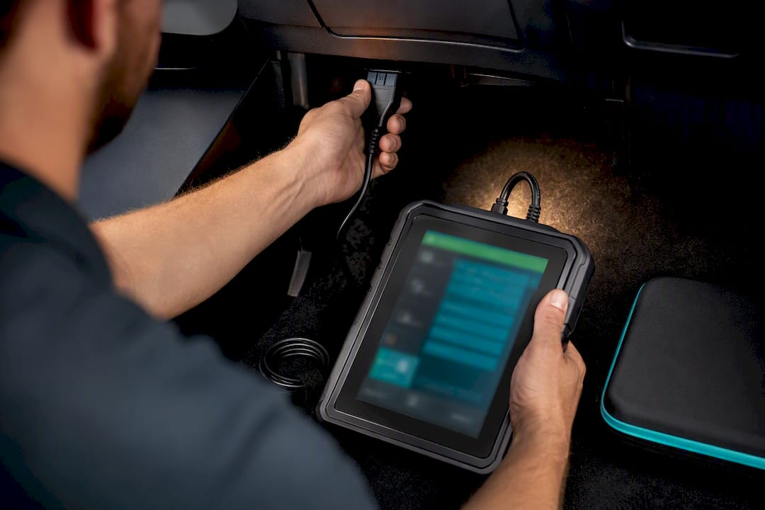 Technician connecting automotive diagnostic scan tool