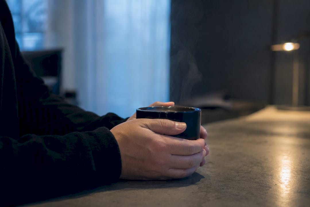 Hands holding coffee cup in quiet reflection