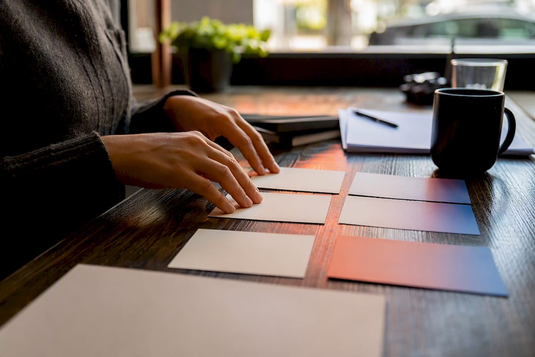 Persona che sistema delle schede con la checklist per la voce del brand