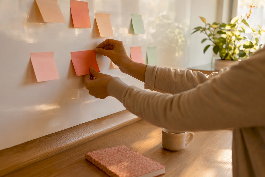Hands pinning strategy notes on corkboard