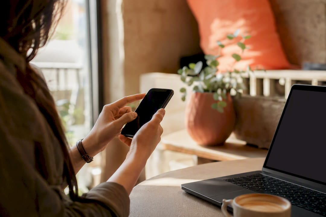 Hand tapping smartphone screen on desk