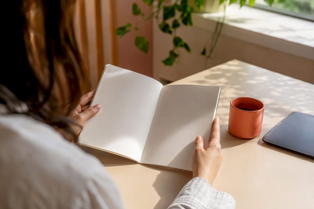 Hands holding tablet near coffee on desk