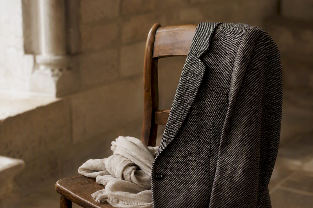 Structured blazer on wooden chair in soft natural light