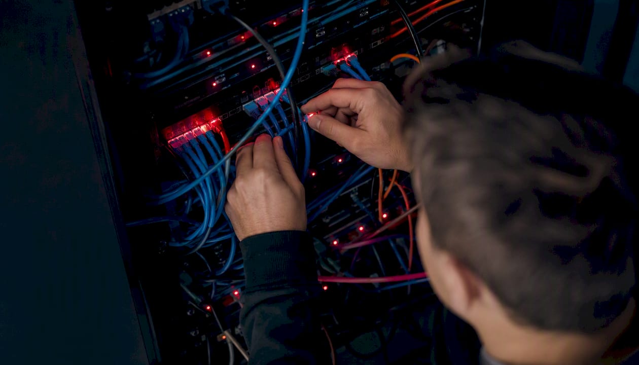 Hands connecting cables in server rack