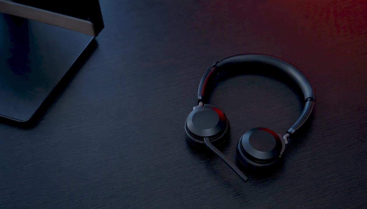 Empty office desk with headset and dark lighting