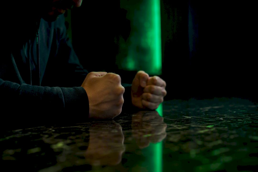 Clenched fists showing trading stress in neon light