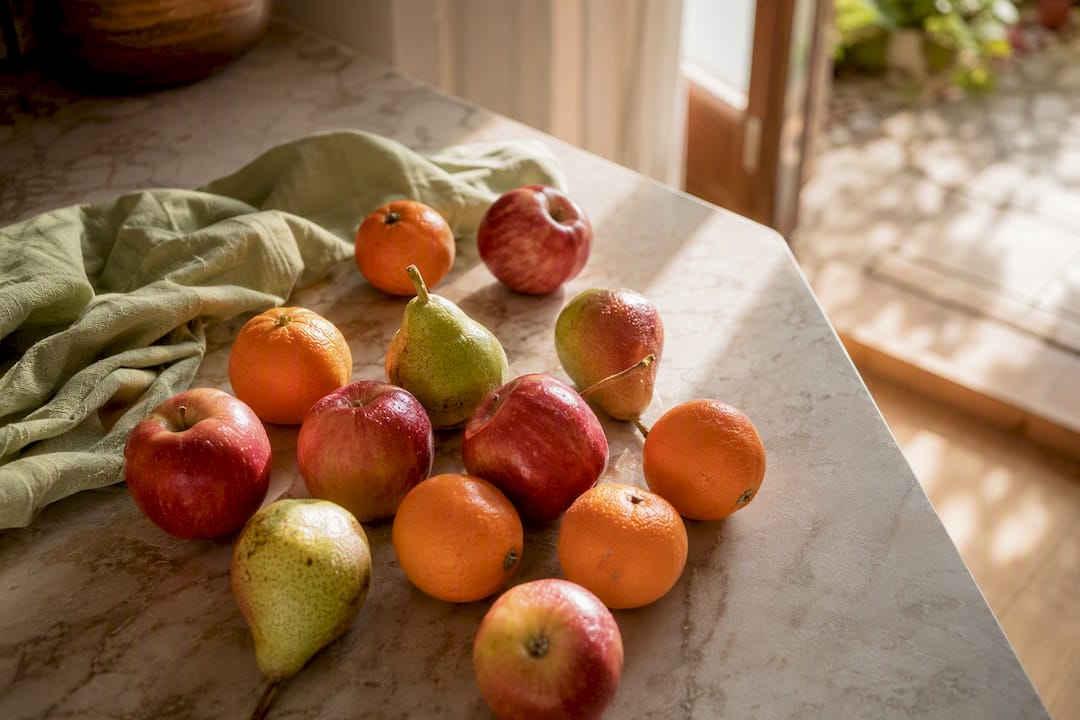 Fresh apples, oranges, and pears on table