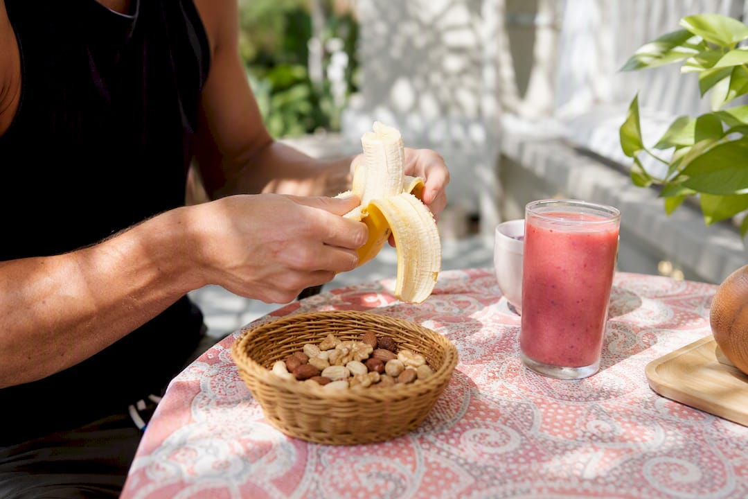 Hands peeling banana for pre-workout snack