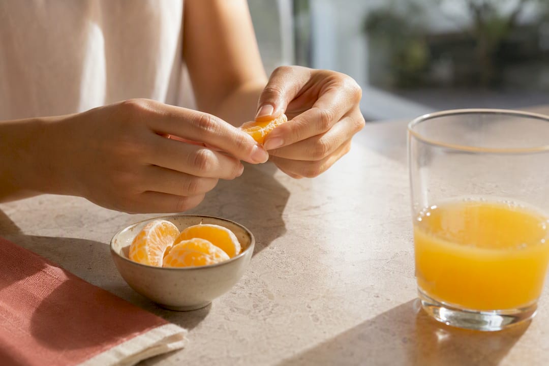 Citrus segments beside a glass of juice