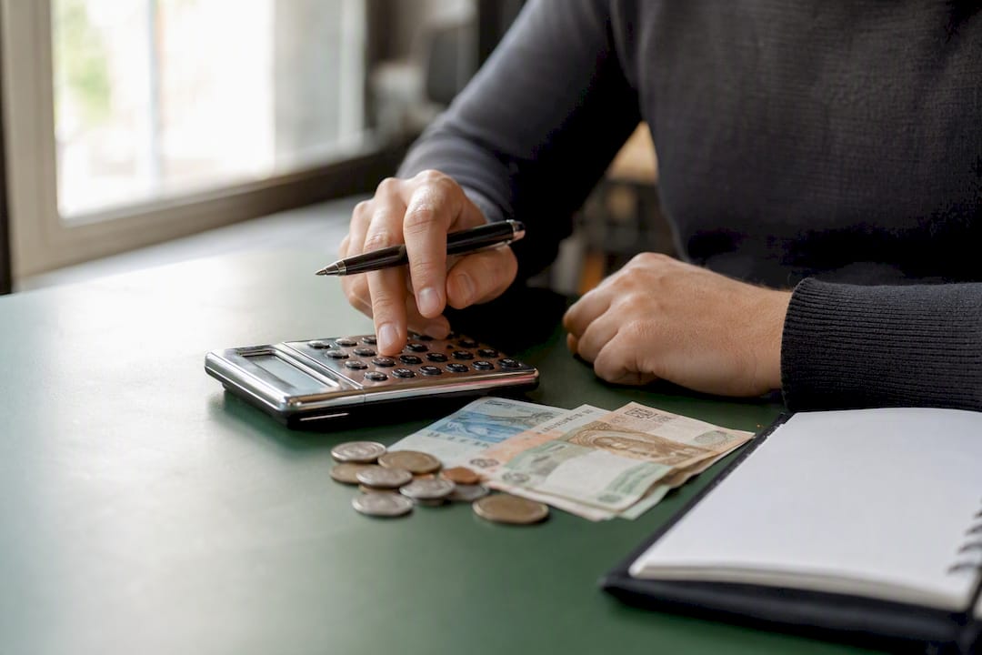 Hands arranging financial tools on navy desk