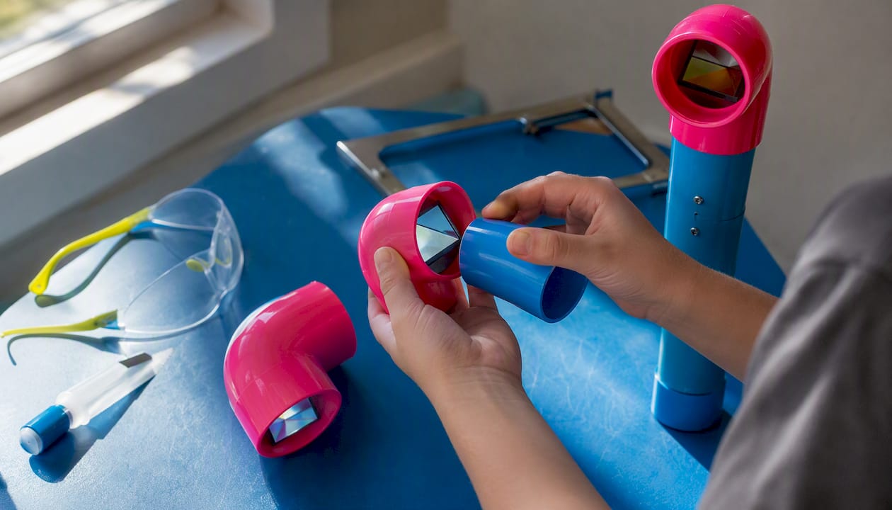 Hands assembling PVC pipe periscope
