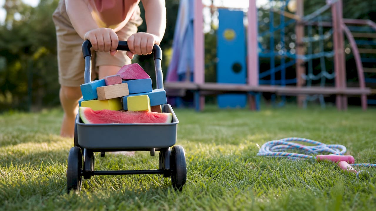 Hands pushing weighted toy cart