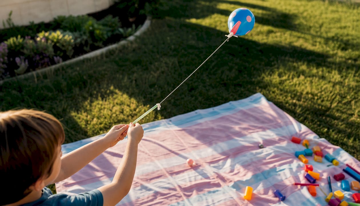 Child hands ready to launch balloon rocket on string