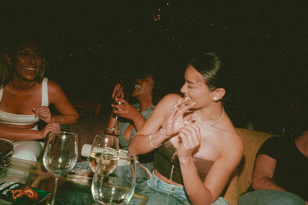 a group of people sitting around a table with wine glasses