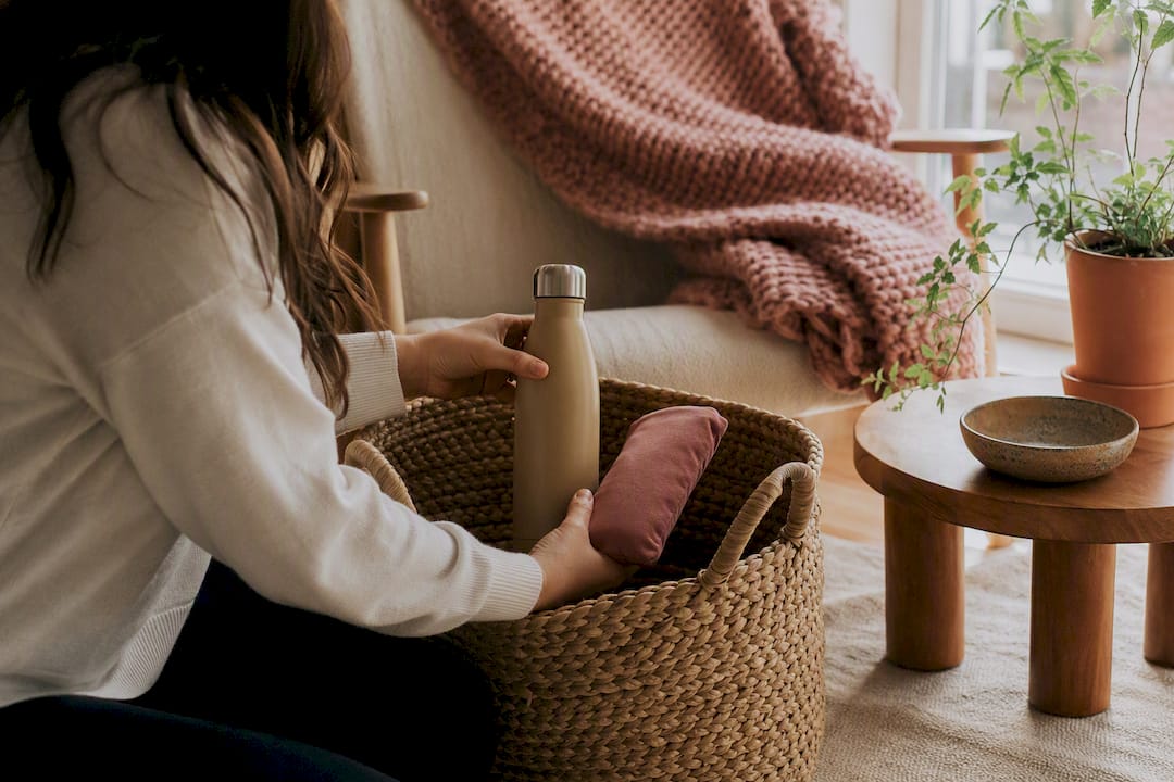 Hands arranging portable period comfort items on table