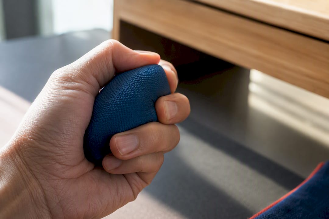 Hand squeezing a stress ball during work