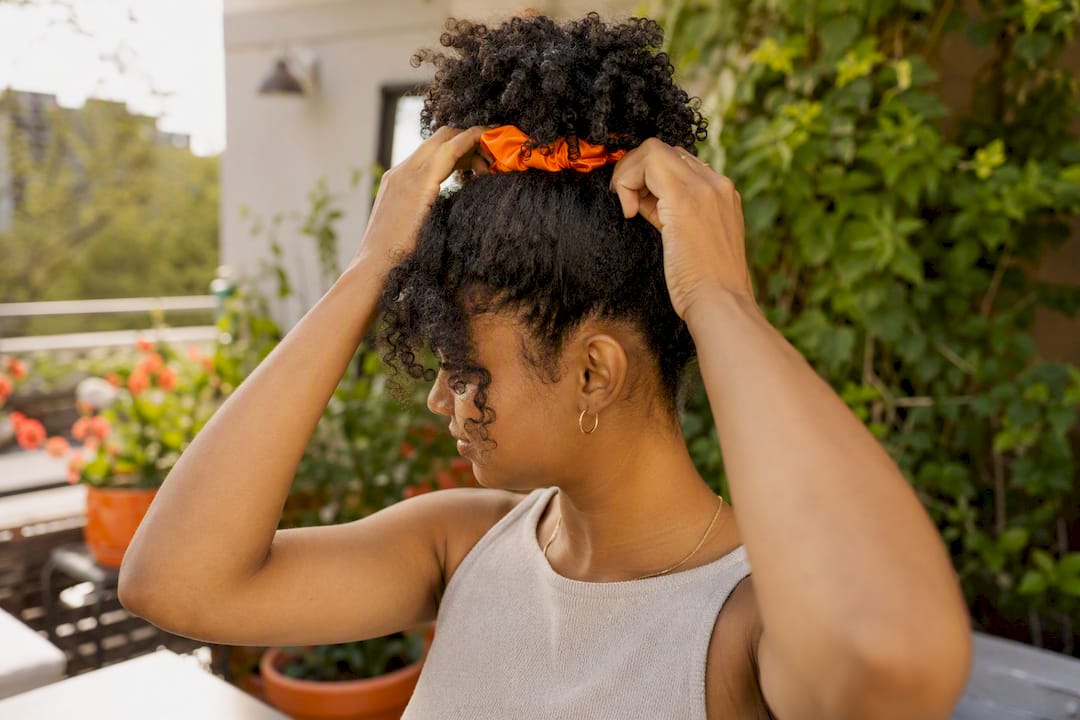 Hands forming pineapple tuck updo