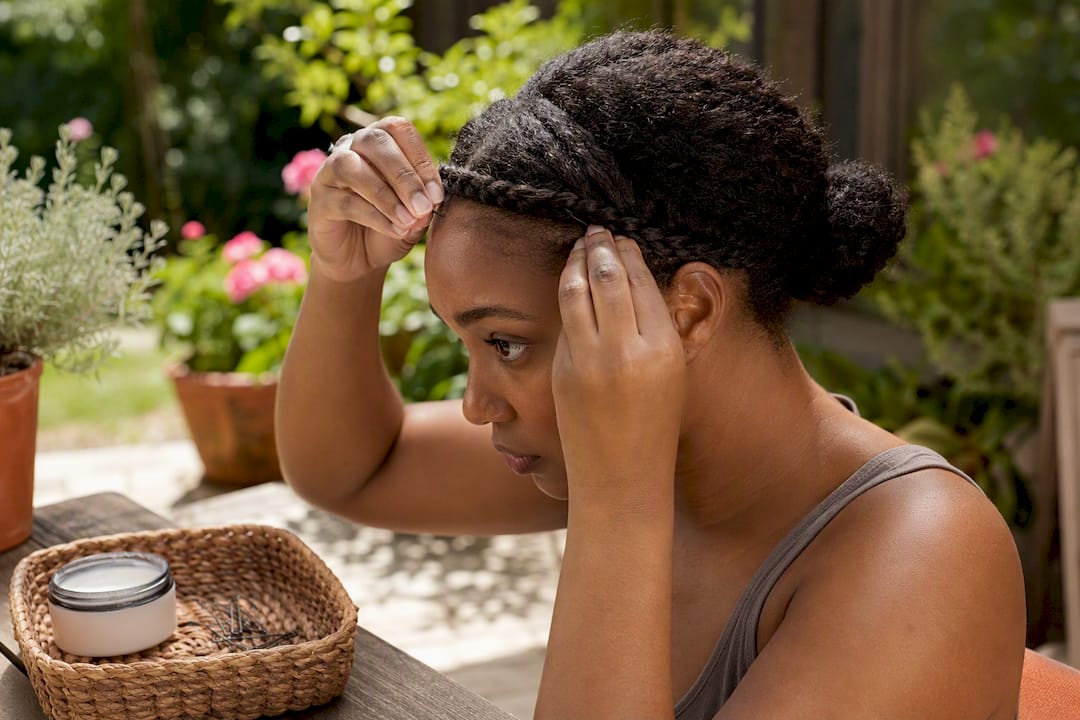 Woman pinning braided headband into updo