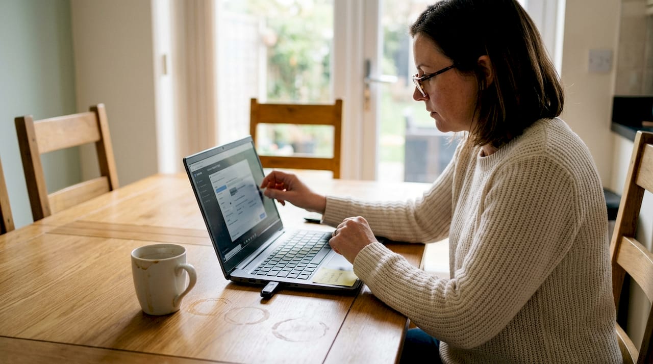 Woman setting video compression on laptop