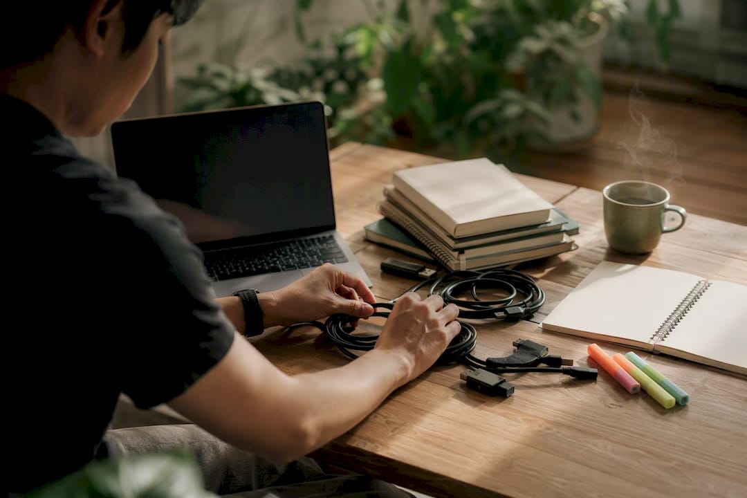 Hands placing network cables in modern workspace